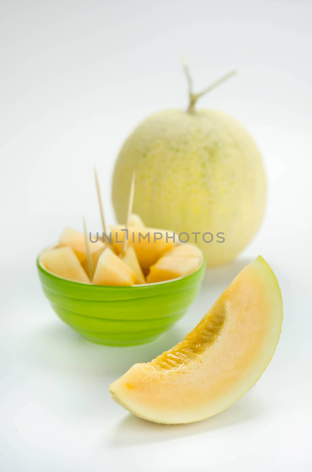 Ripe melon with slice on white background