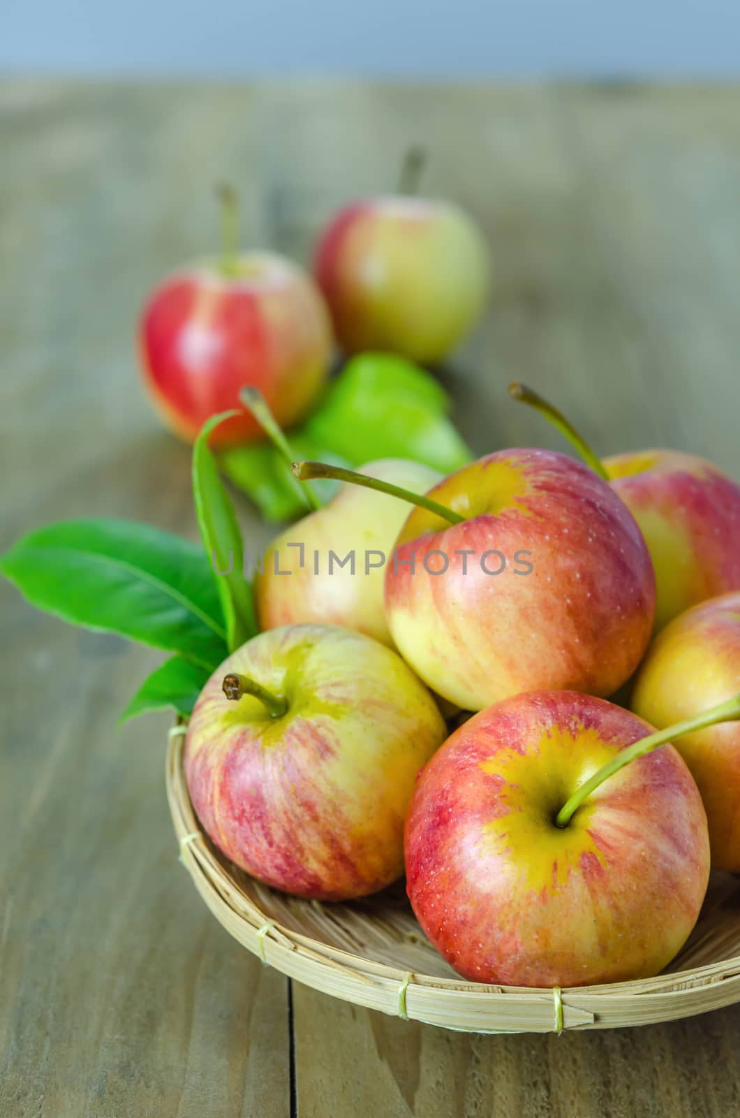Red and yellow apple  with bamboo basket , organic fresh fruit on wooden background