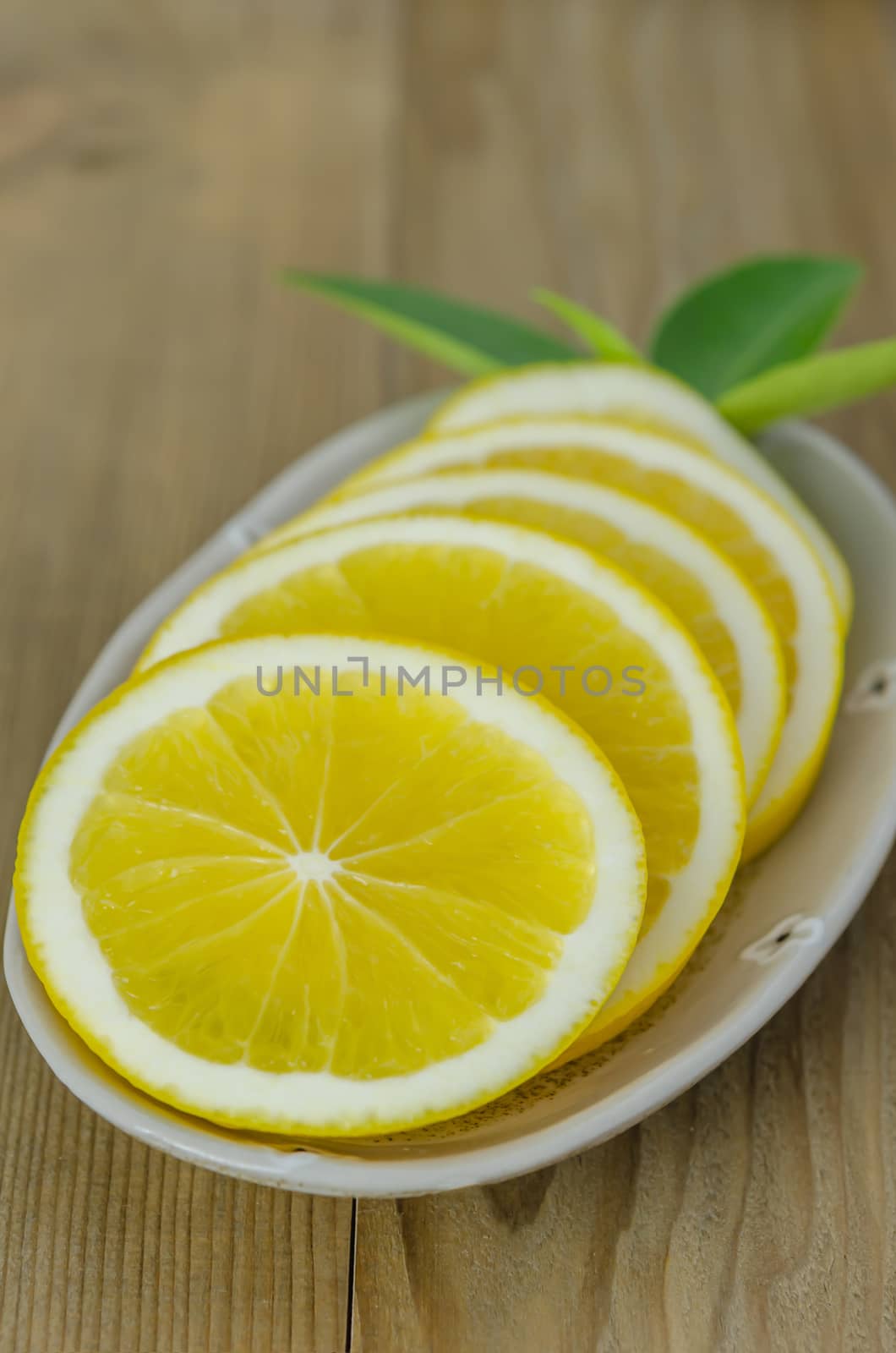 slice orange on dish over wooden background