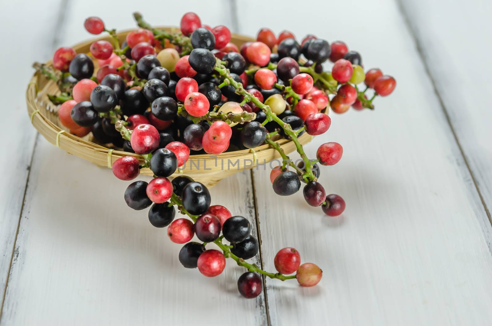 Thai Blueberry in bamboo basket over wooden background