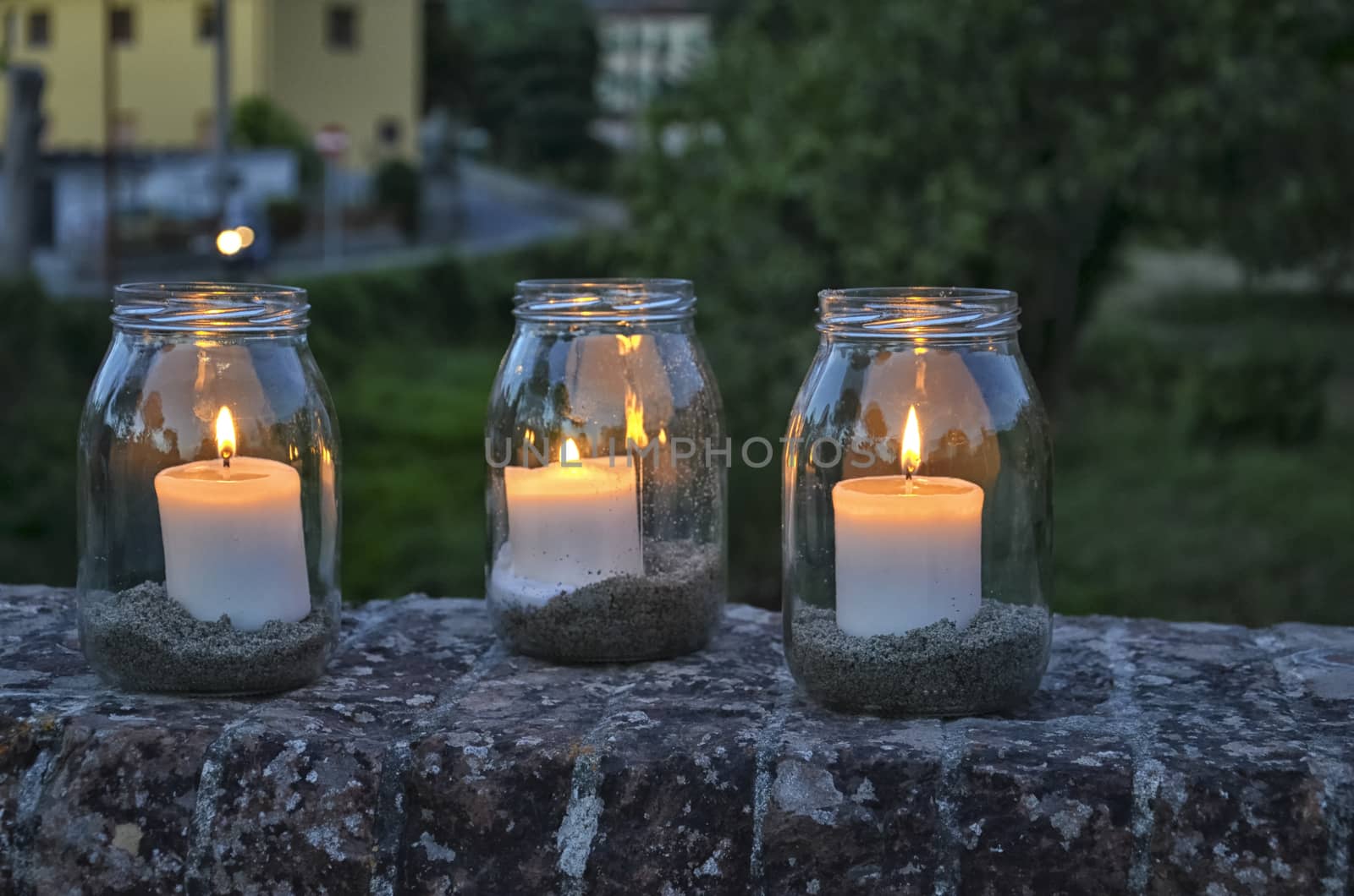 View of glass jars with lit candles inside