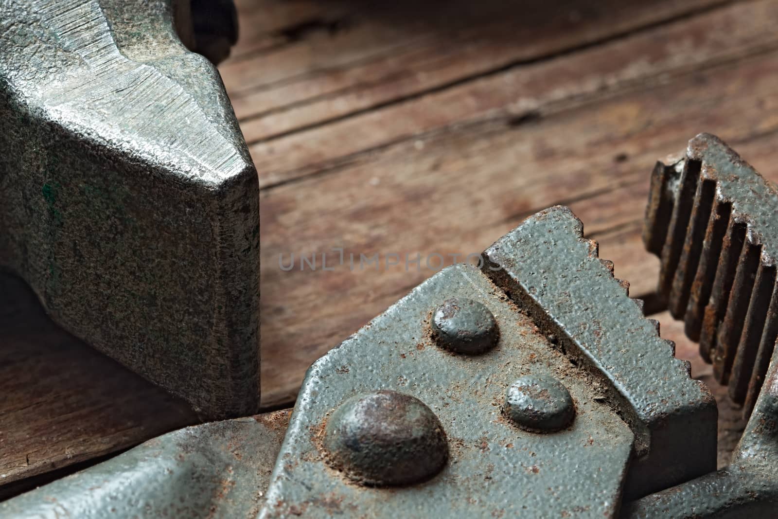 Adjustable wrench and a hammer on a rough wooden background. Still life: old tools with traces of use and rust. Close up selective focus image with copy-space.