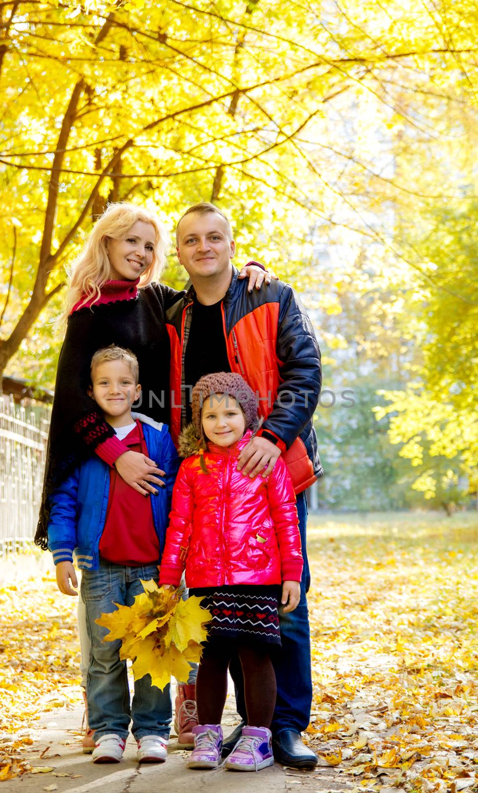 Happy family of four in autumn park