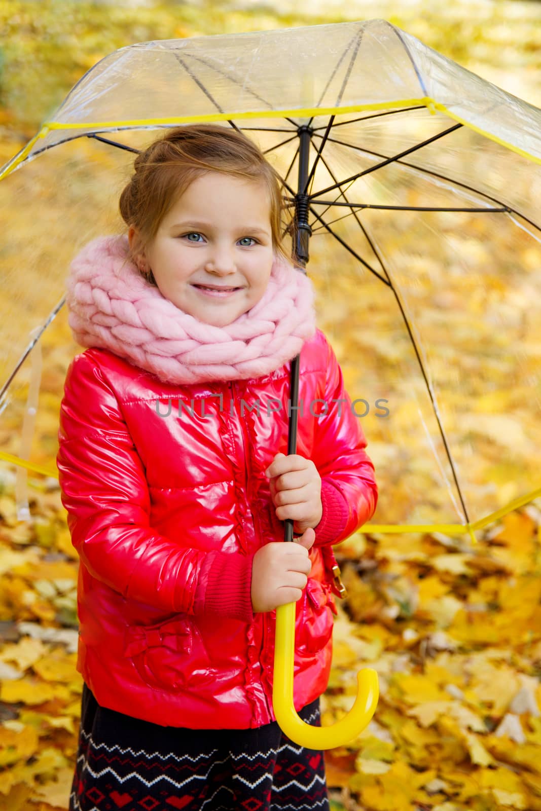 Smiling girl with umbrella on autumn back