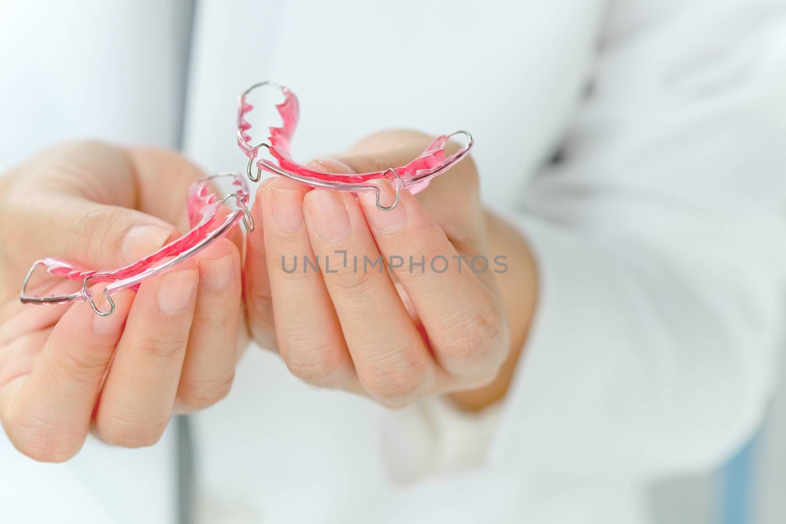 Dentist holding Retainer, Orthodontics Dental concept background