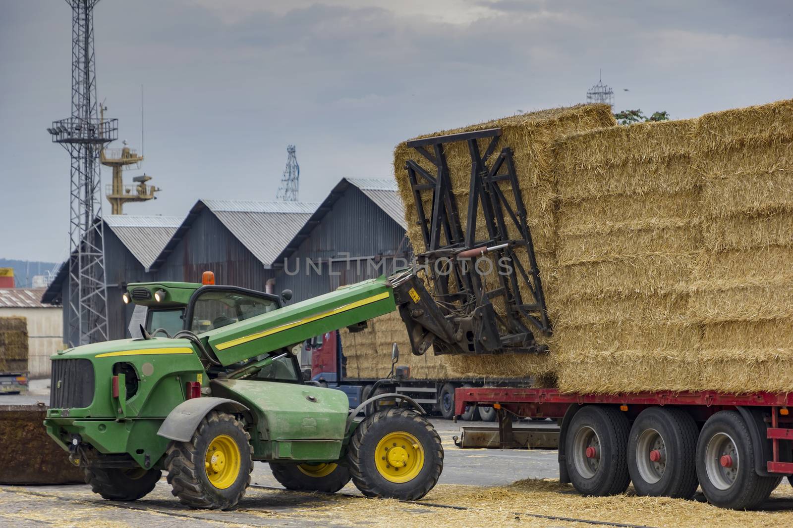 unloading bales in port from truck with telehandler