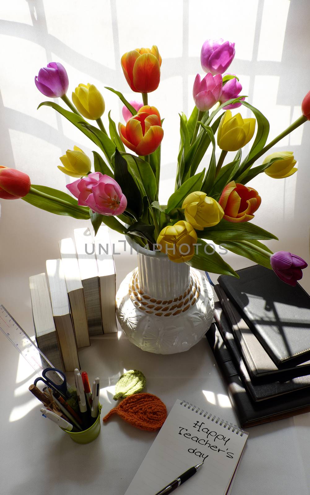 Happy teachers day with handmade tulip flower pot, stack of books, pen, message for teacher in special day of education, tulip bouquet diy from clay material