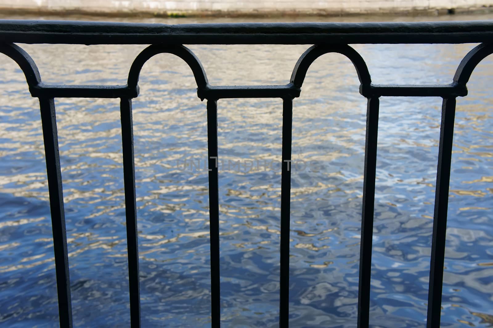 metal railing on the promenade, view of water