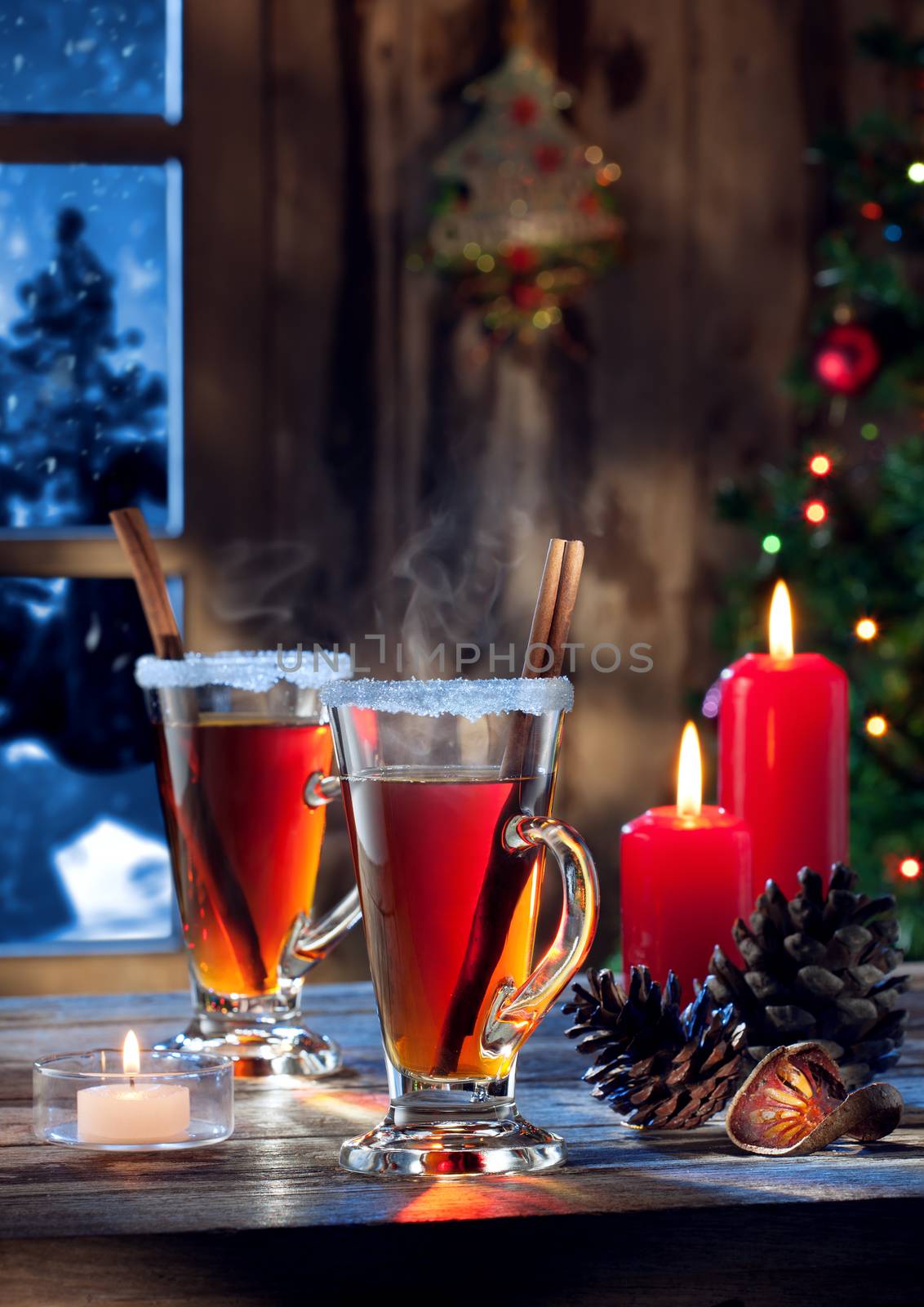 close up view  of glasses  with mulled wine with gift boxes on color back