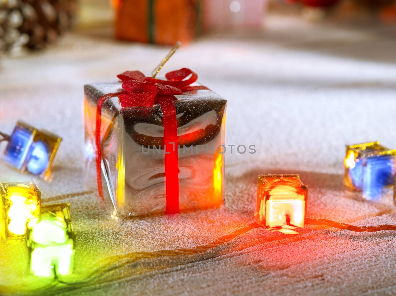 close up view  of lights and gift box on snowbound  wooden back