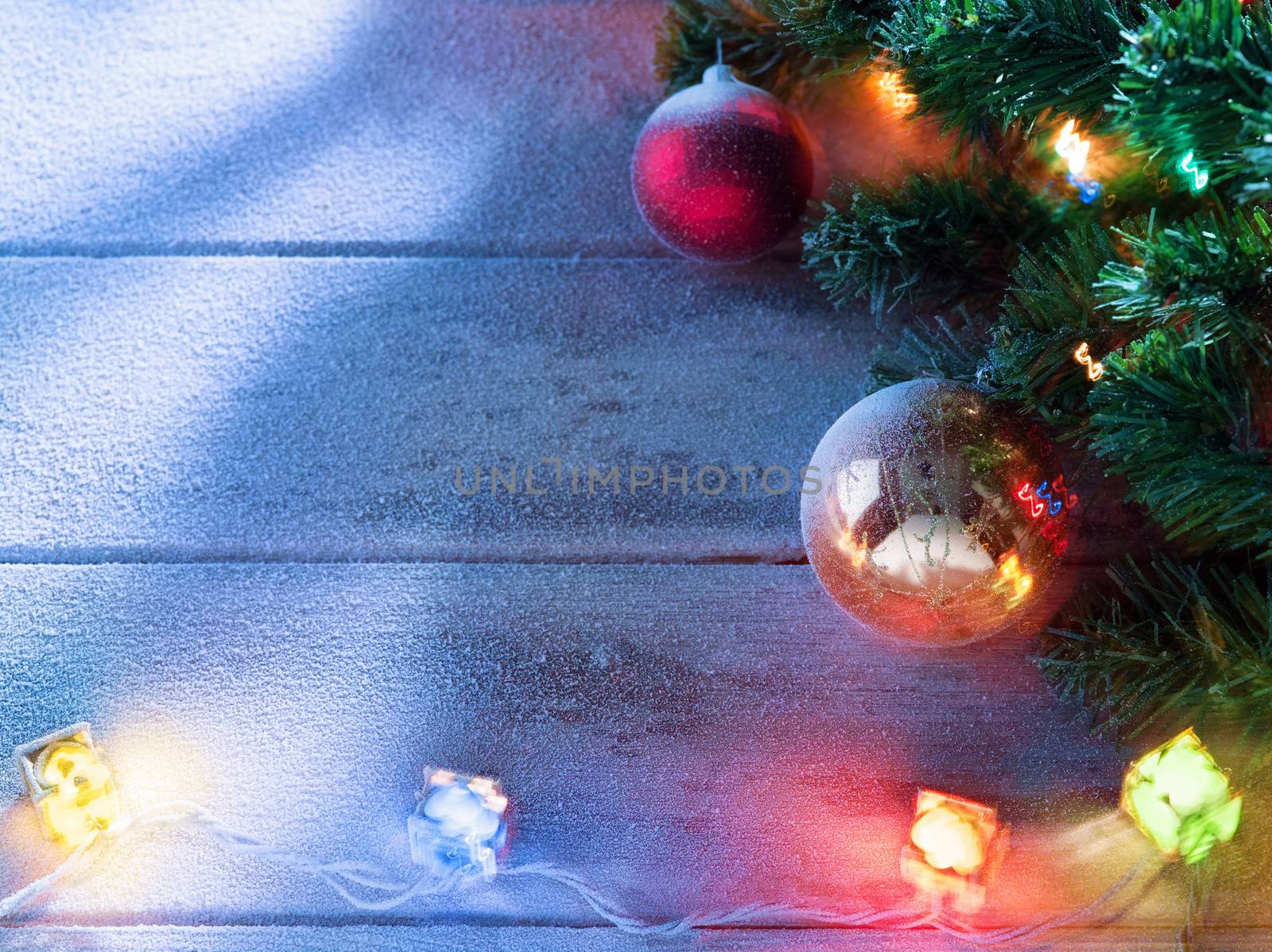 close up view  of lit Christmas tree on snowbound  wooden back