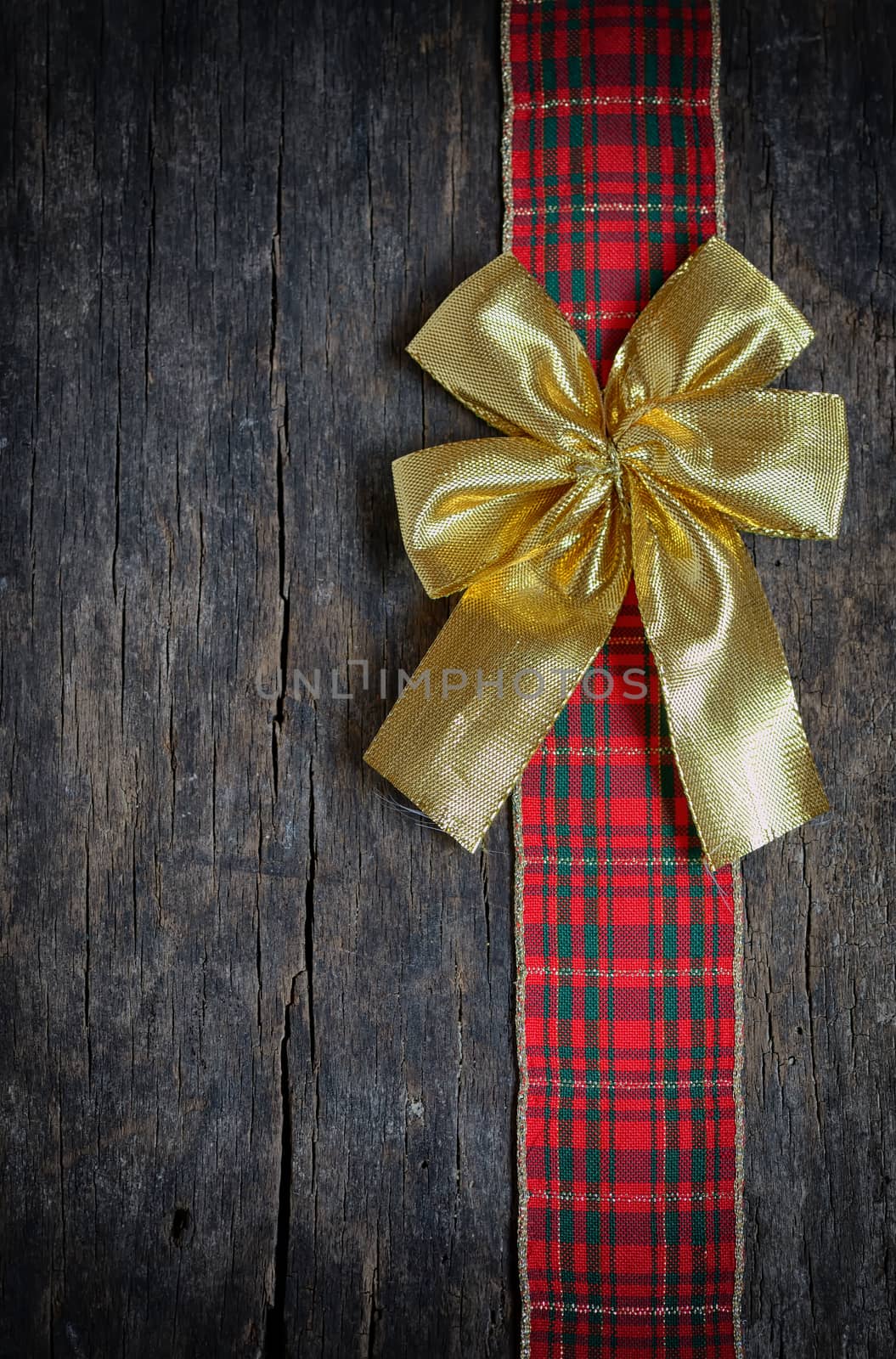 Christmas  ribbon and golden gift bow isolated on old wooden background
