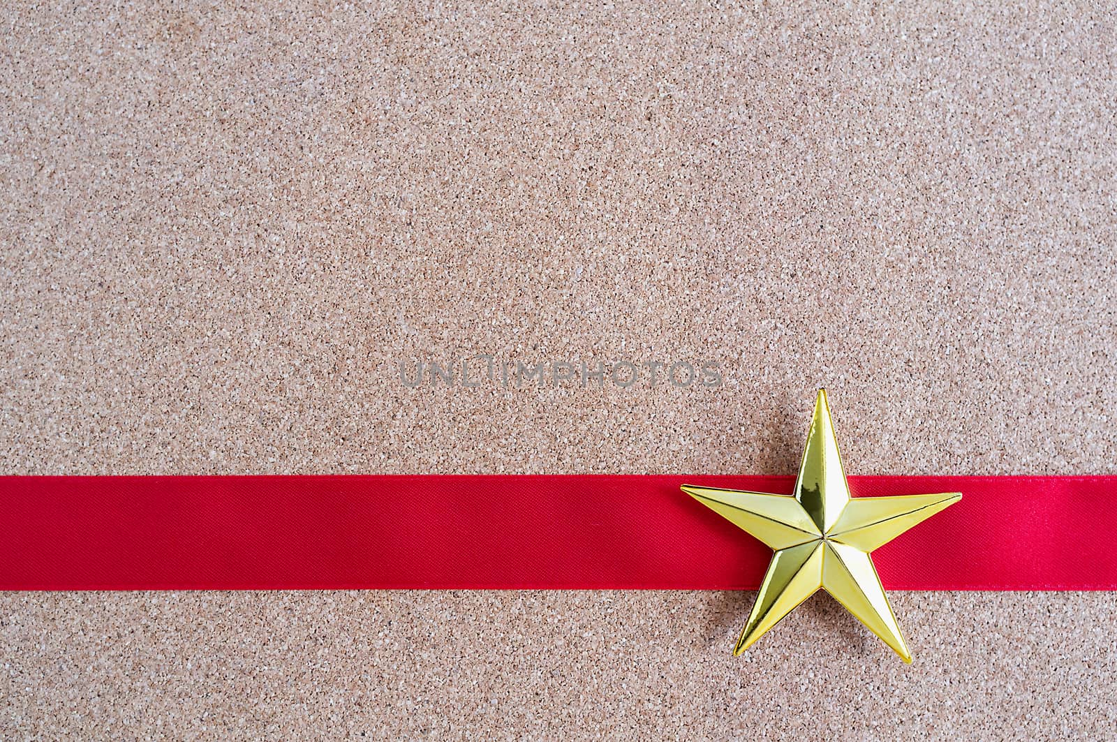 Christmas golden star and red ribbon on cork board. Christmas pattern.