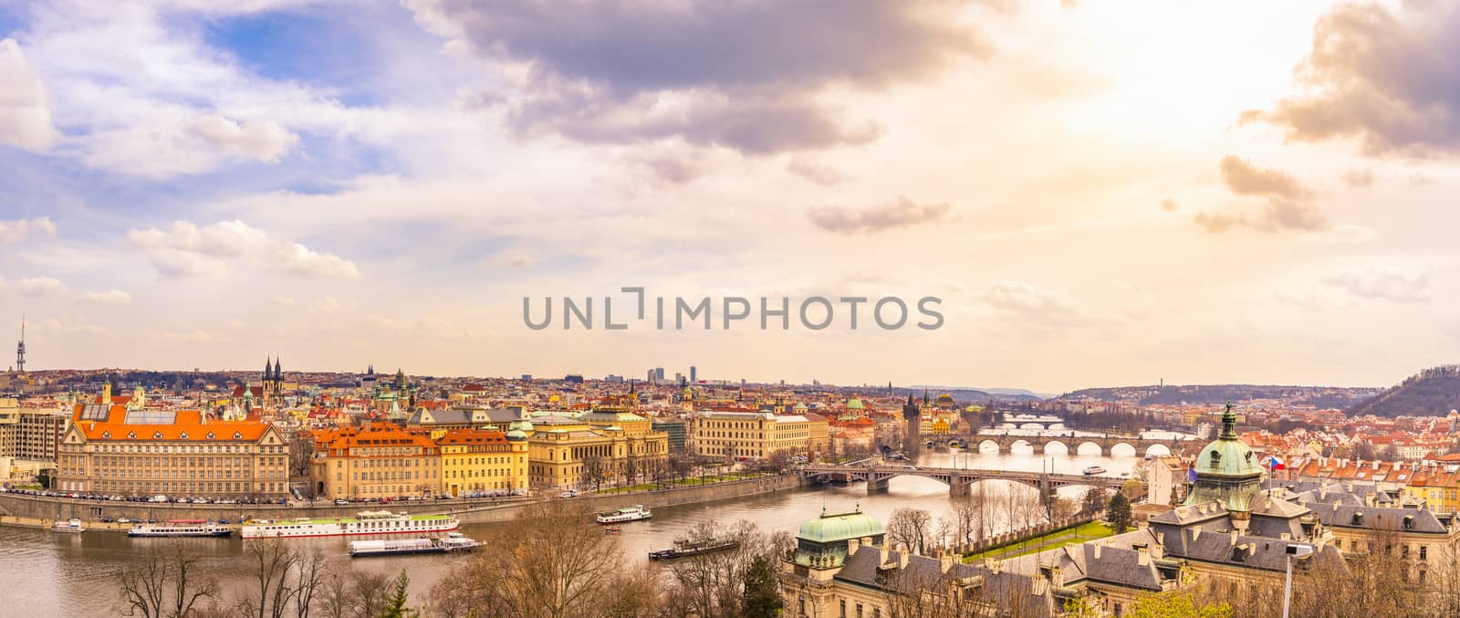 Cityscape panorama  of Prague, the capital of Czech Republic, with the Vltava river, the bridges, and all its buildings, under an afternoon sky.