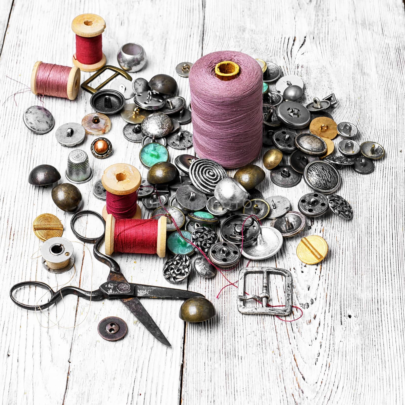 Spools of sewing threads and buttons from clothing