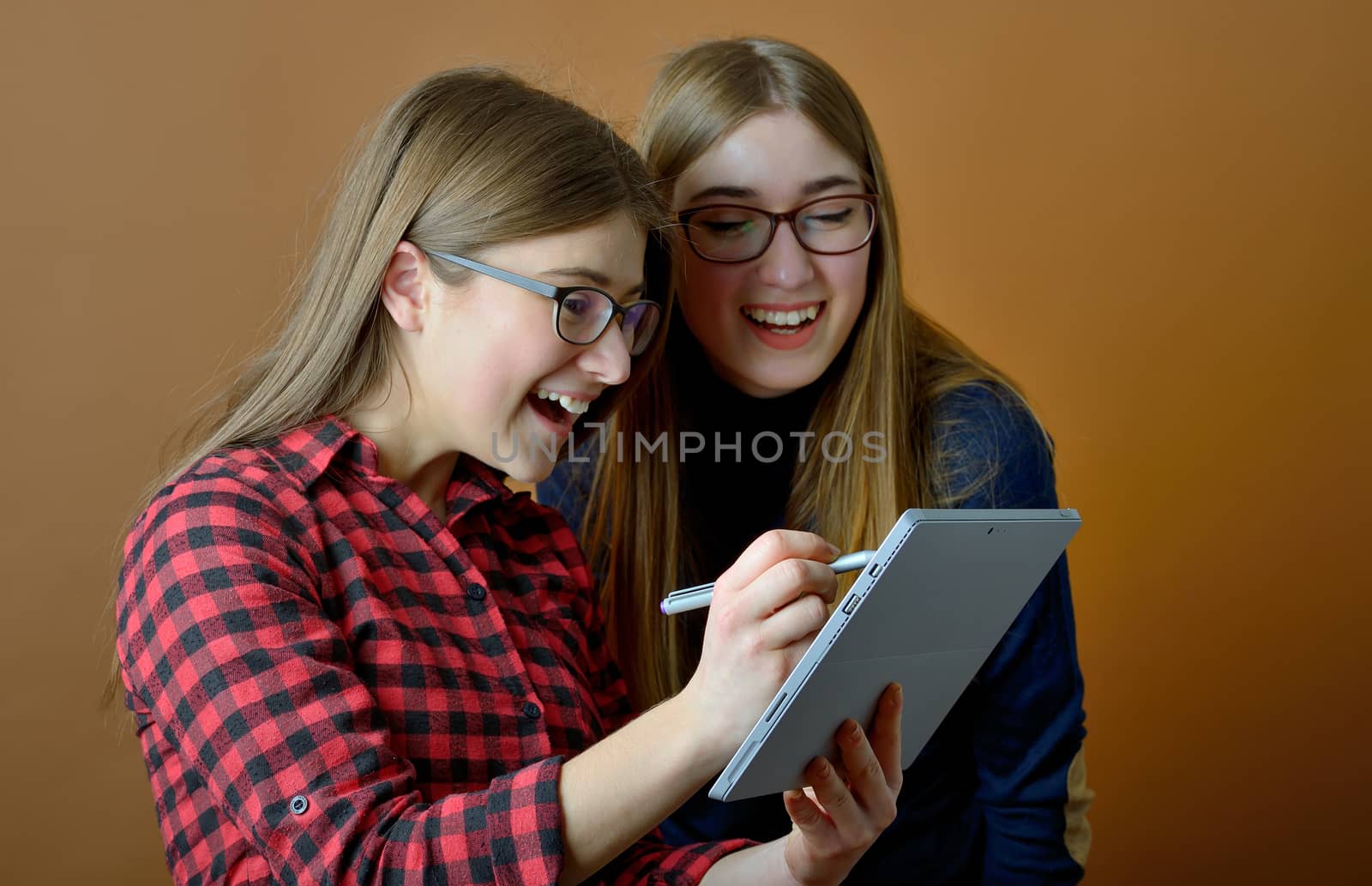 Two young girls using pc tablet in studio
