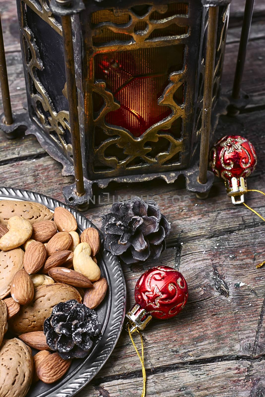 Almonds,cashews against Eastern lamp and Christmas decorations