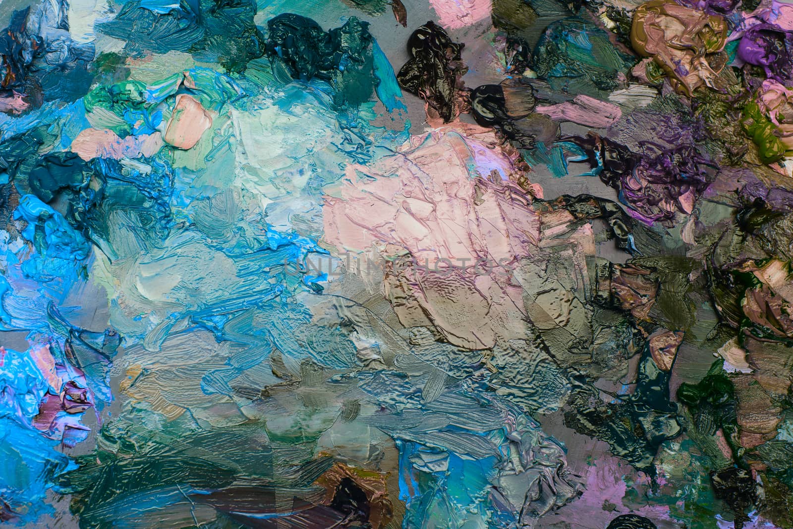 artists oil paints on wooden palette. macro artist's palette, texture mixed oil paints in different colors and saturation. art palette background