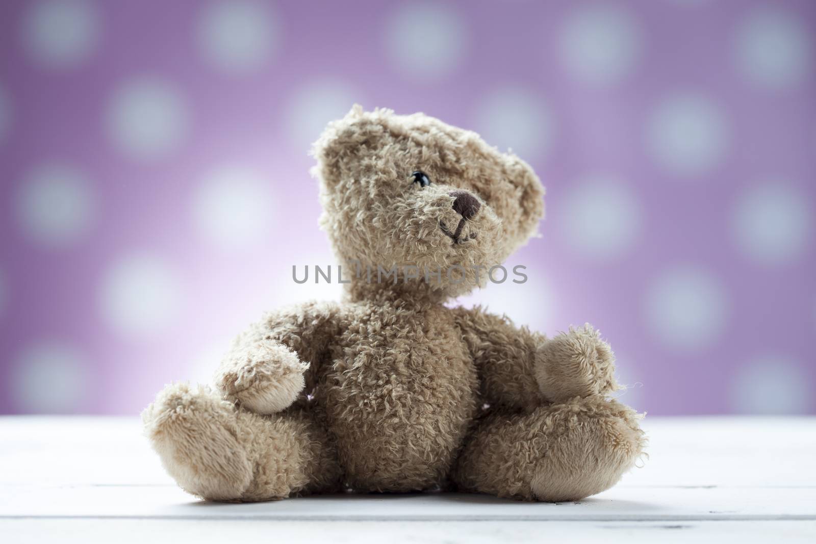 Teddy bear sitting on white wooden desk
