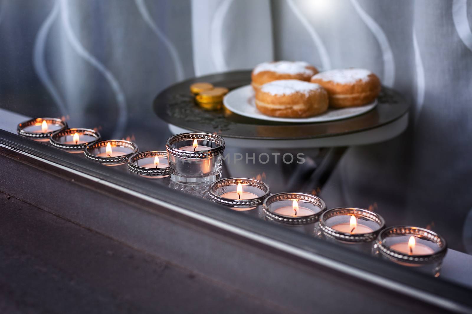 The Symbols of Hanukkah - nine-branched mehorah Hanukiah , sufganiyot and chocolate coins in the window