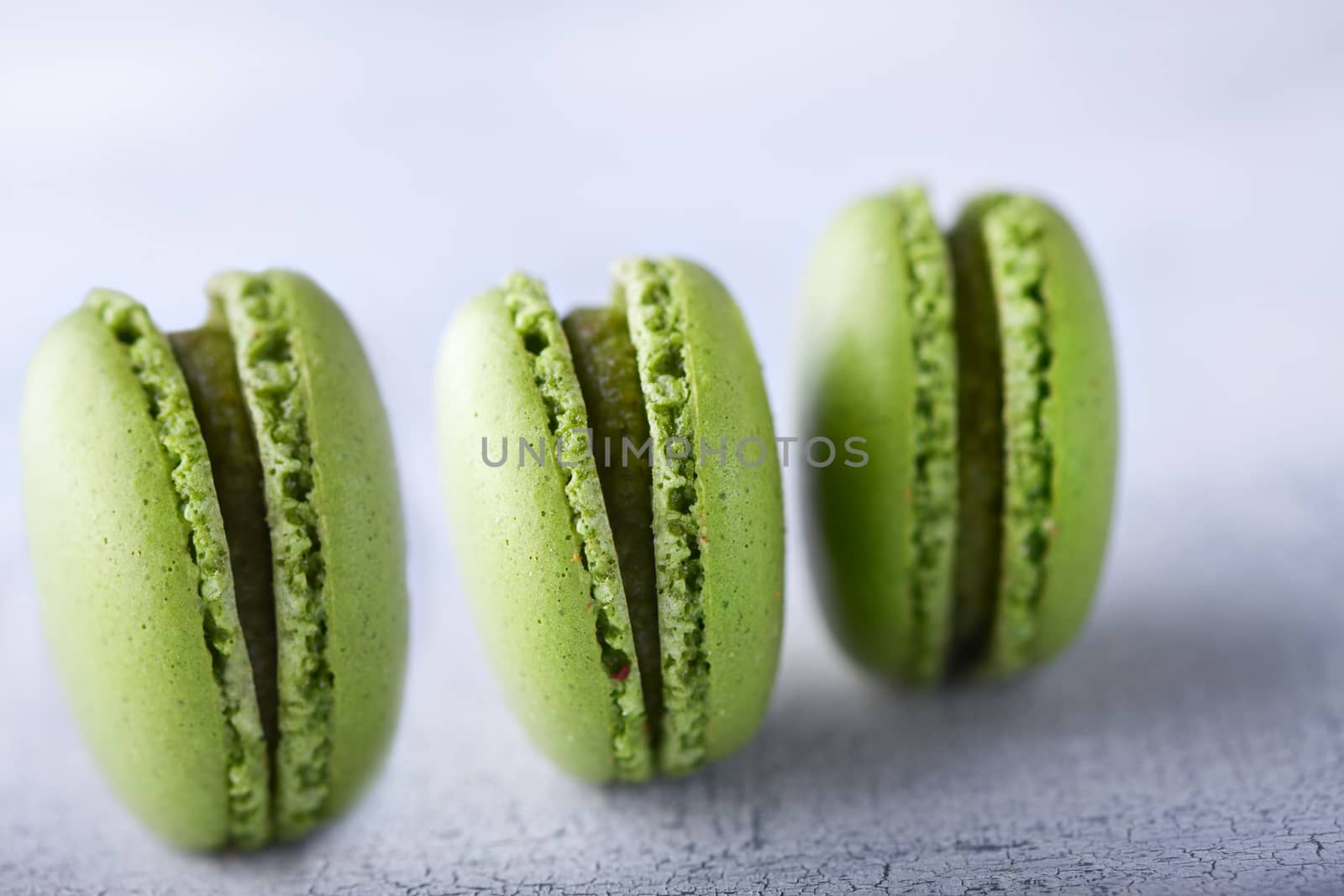 Three green french pistachios Macaroons on a table