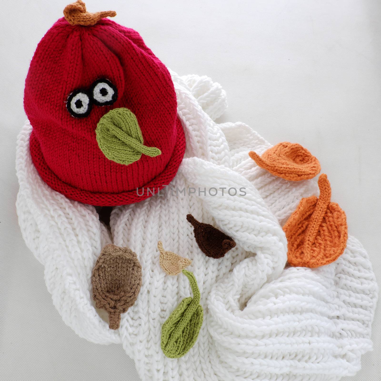 Diy funny, humor Christmas background handmade with lazy snowman from white scarf, red hat, eye and group of knitted leaf from yarn, winter leaves drop on head in cold day, art design for Xmas holiday