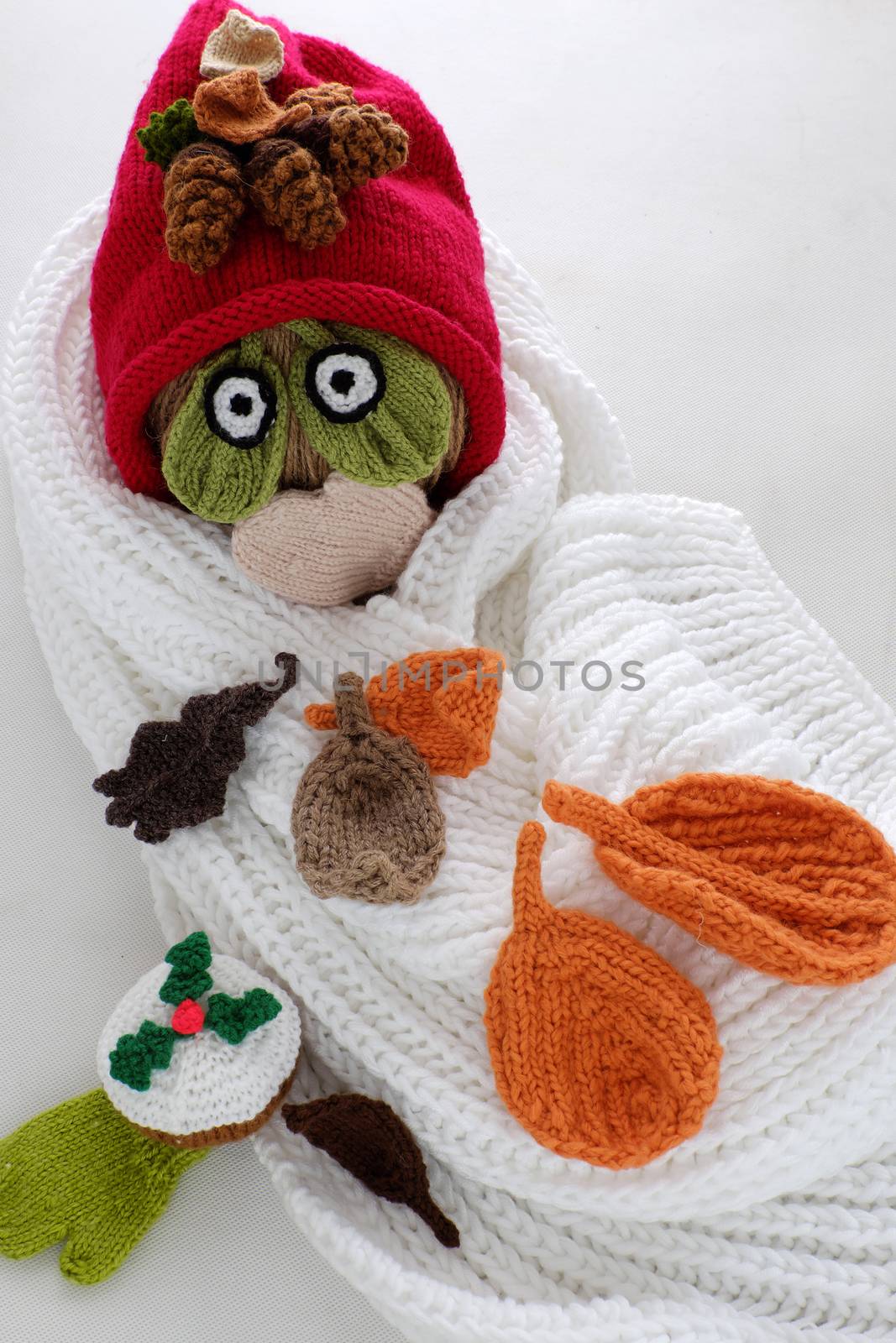 Diy funny, humor Christmas background handmade with lazy snowman from white scarf, red hat, eye and group of knitted leaf from yarn, winter leaves drop on head in cold day, art design for Xmas holiday