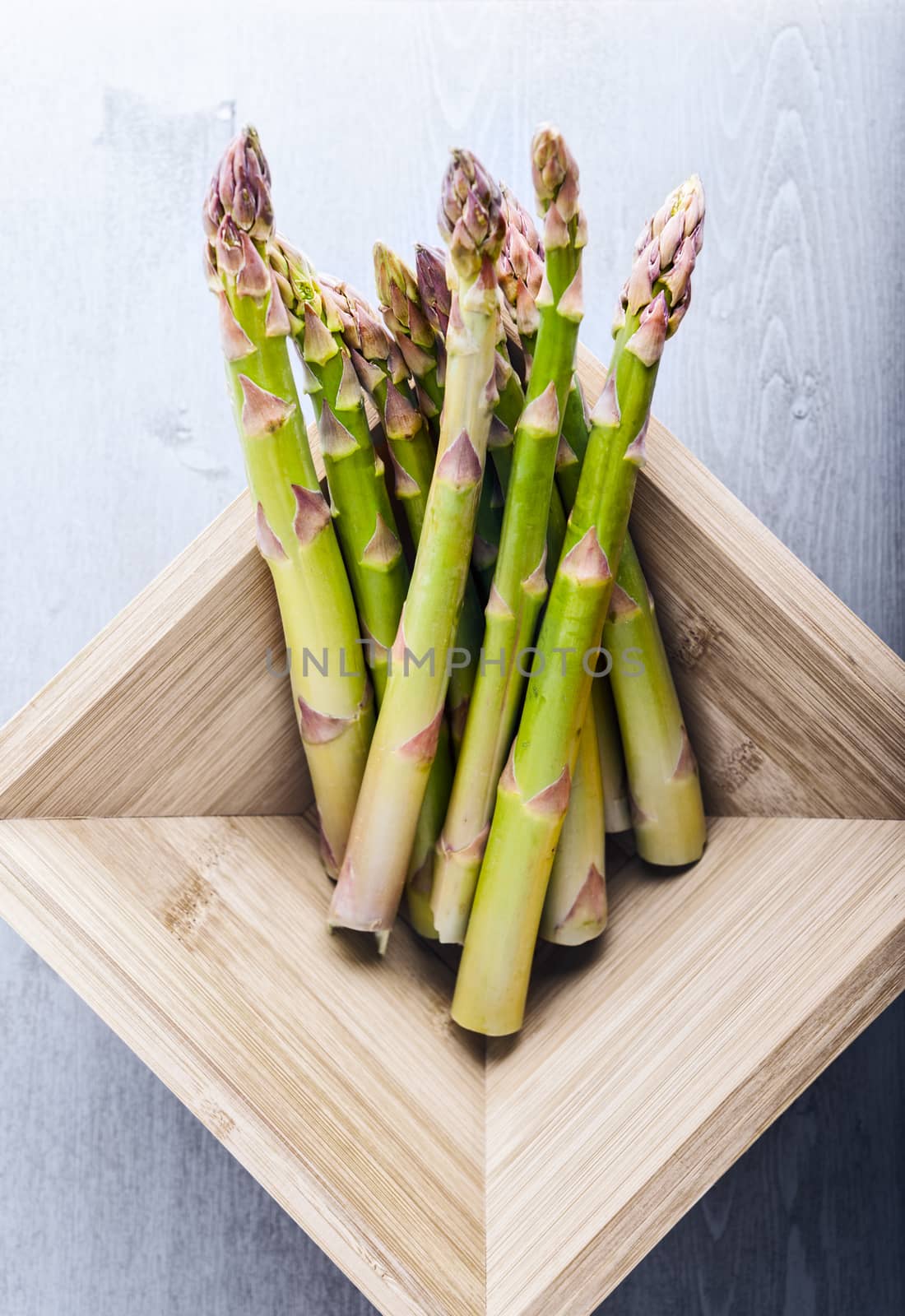 Bunch of green fresh asparagus in a wooden box