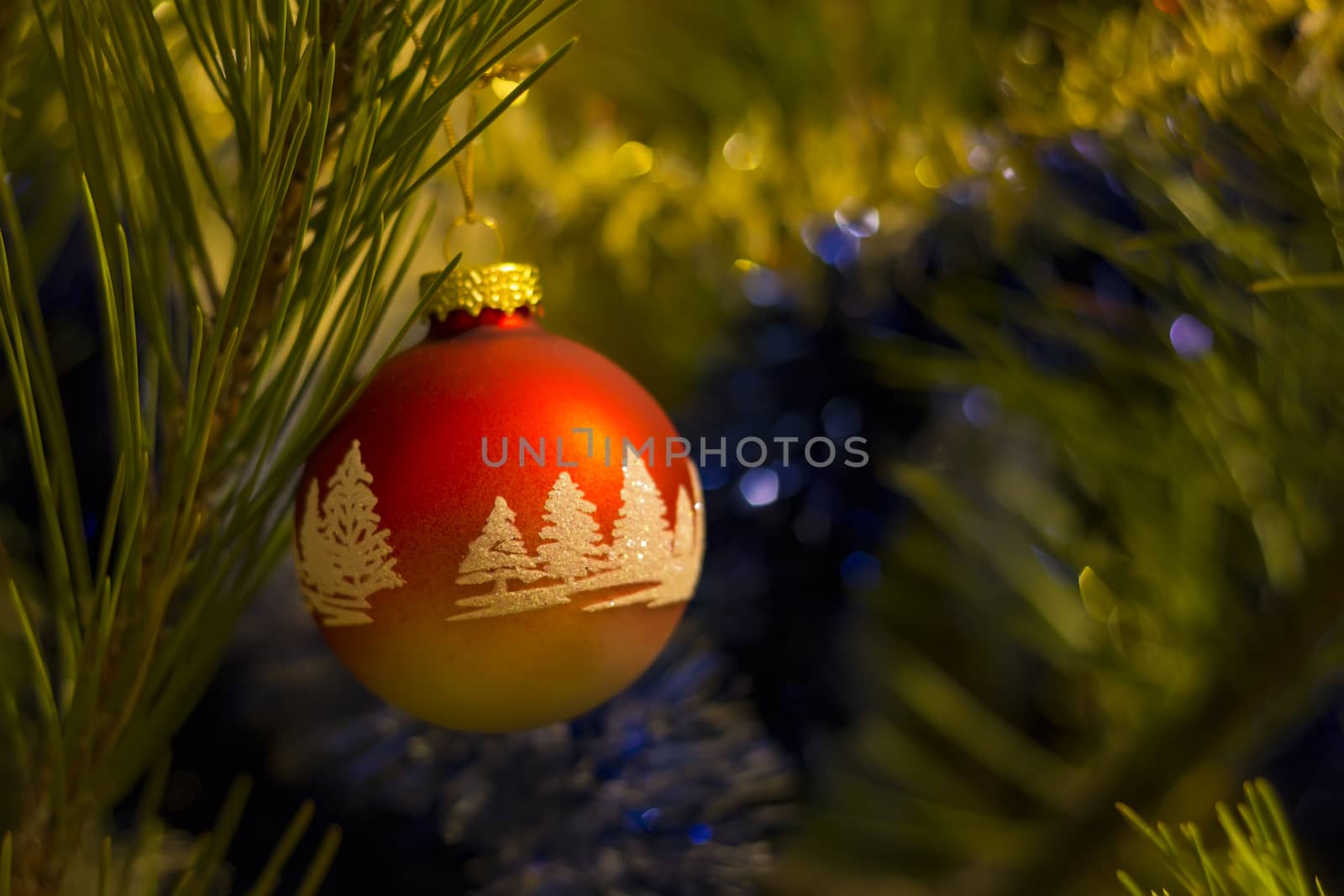 Red Christmas ball with ornaments on christmas tree. Blurred background