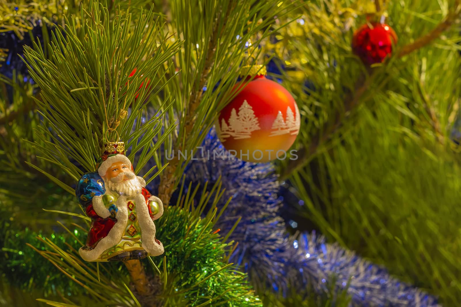 beautiful small santa clause,red christmas balls and garland on christmas tree .