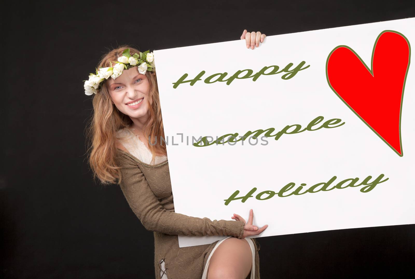 A playful beautiful woman with white roses wreath in her long hair is holding and showing a sign with red heart, sample text and a clipping path.