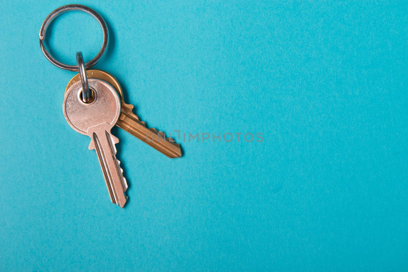 silver house key lying on blue paper background