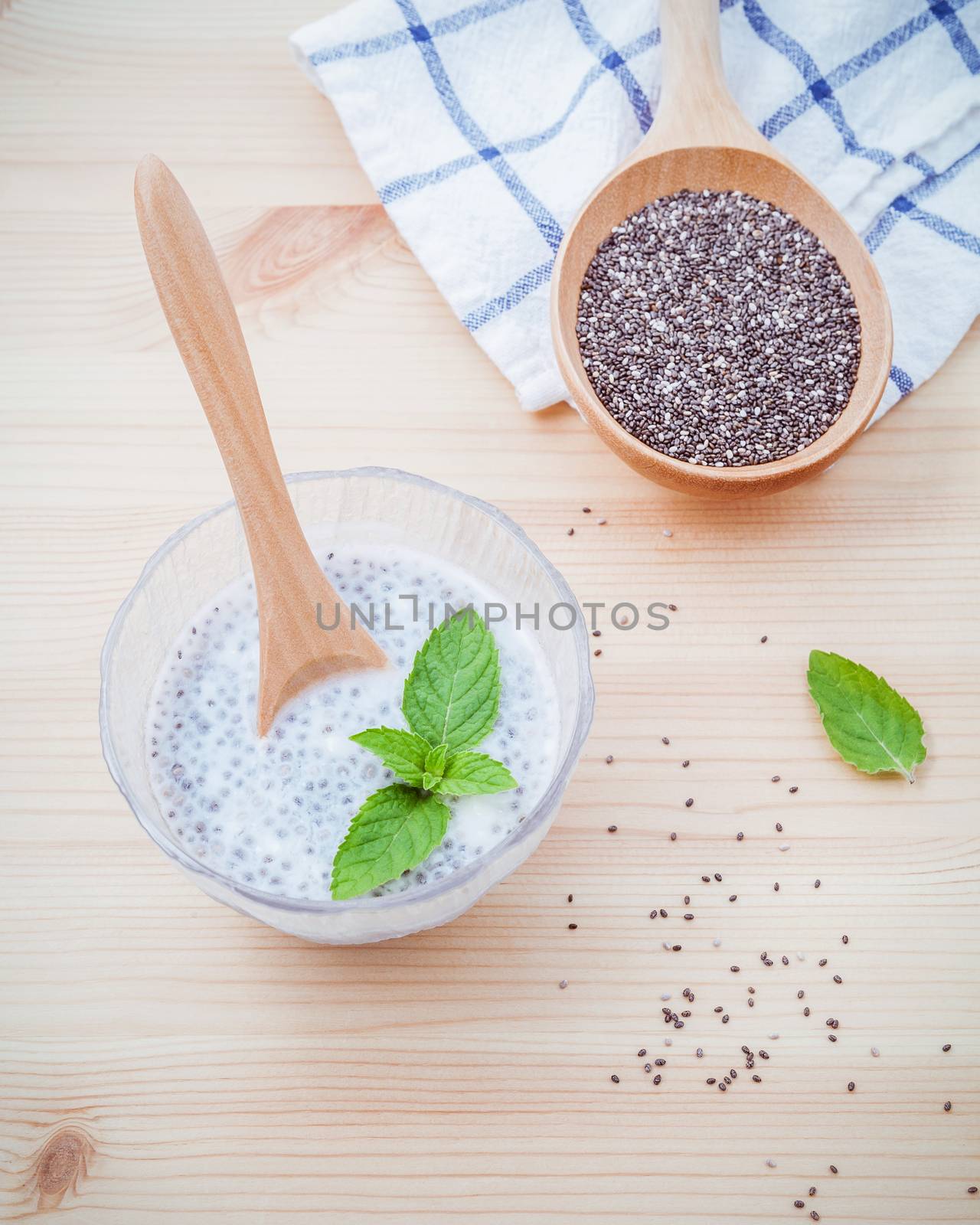 Nutritious chia seeds museli  and peppermint leaves with wooden spoon for diet foods ingredients setup on wooden background . Nutritious Foods and Super foods selection with shallow depth of field.