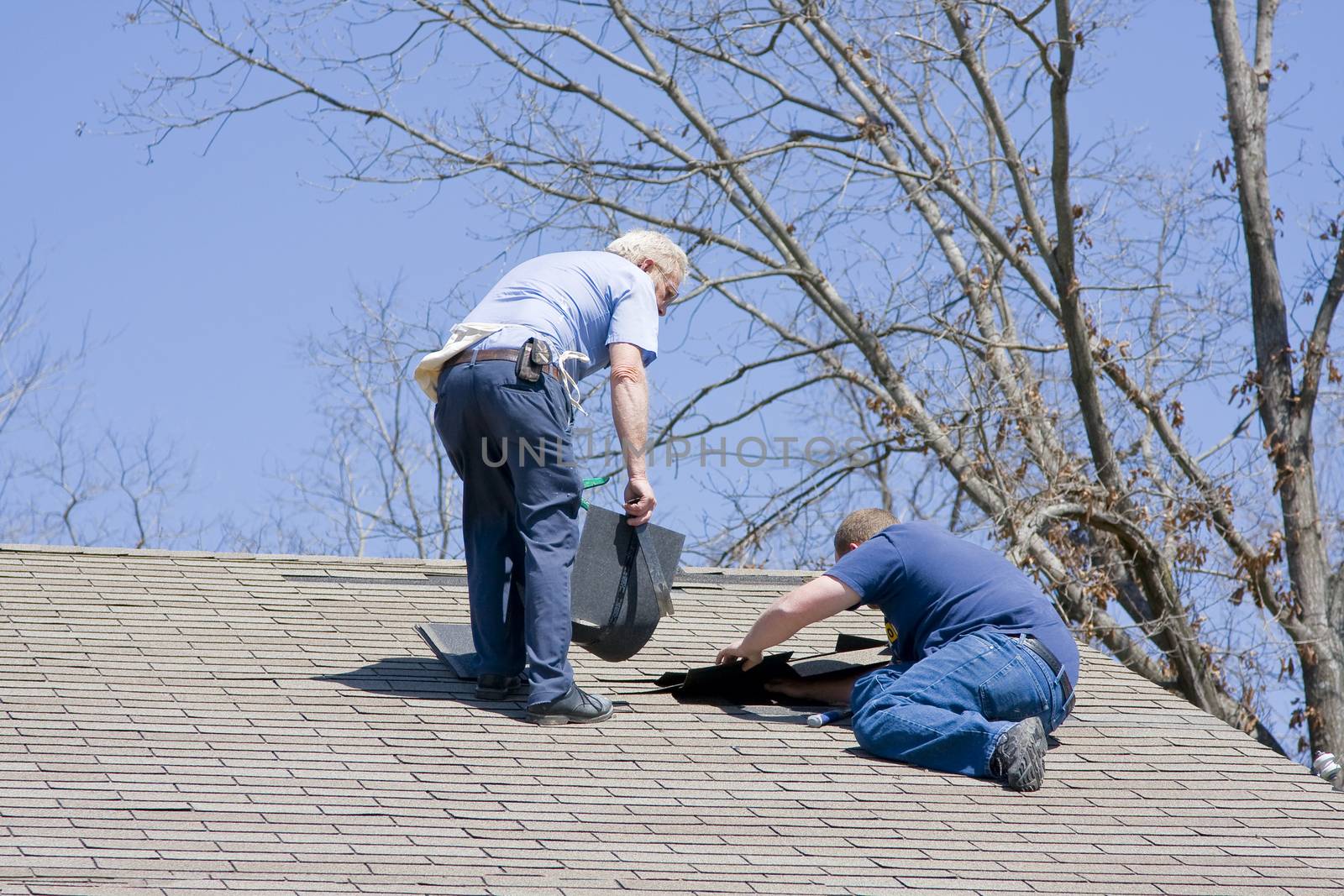 Roofing contractor repairing damaged roof on home after recent wind storms, many roofs were damaged