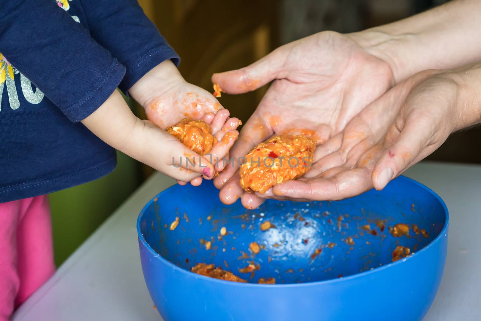 Children and dad hands holding the raw meatballs