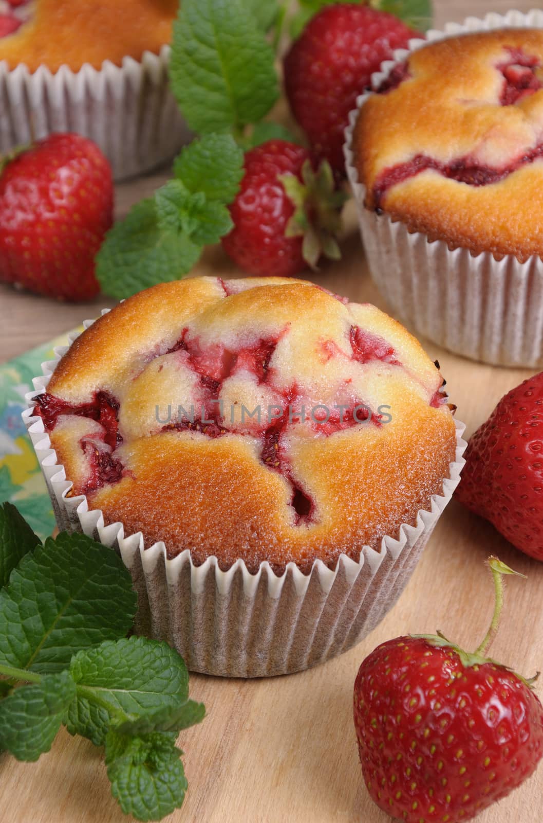 muffin with strawberries on a table among the berries and mint