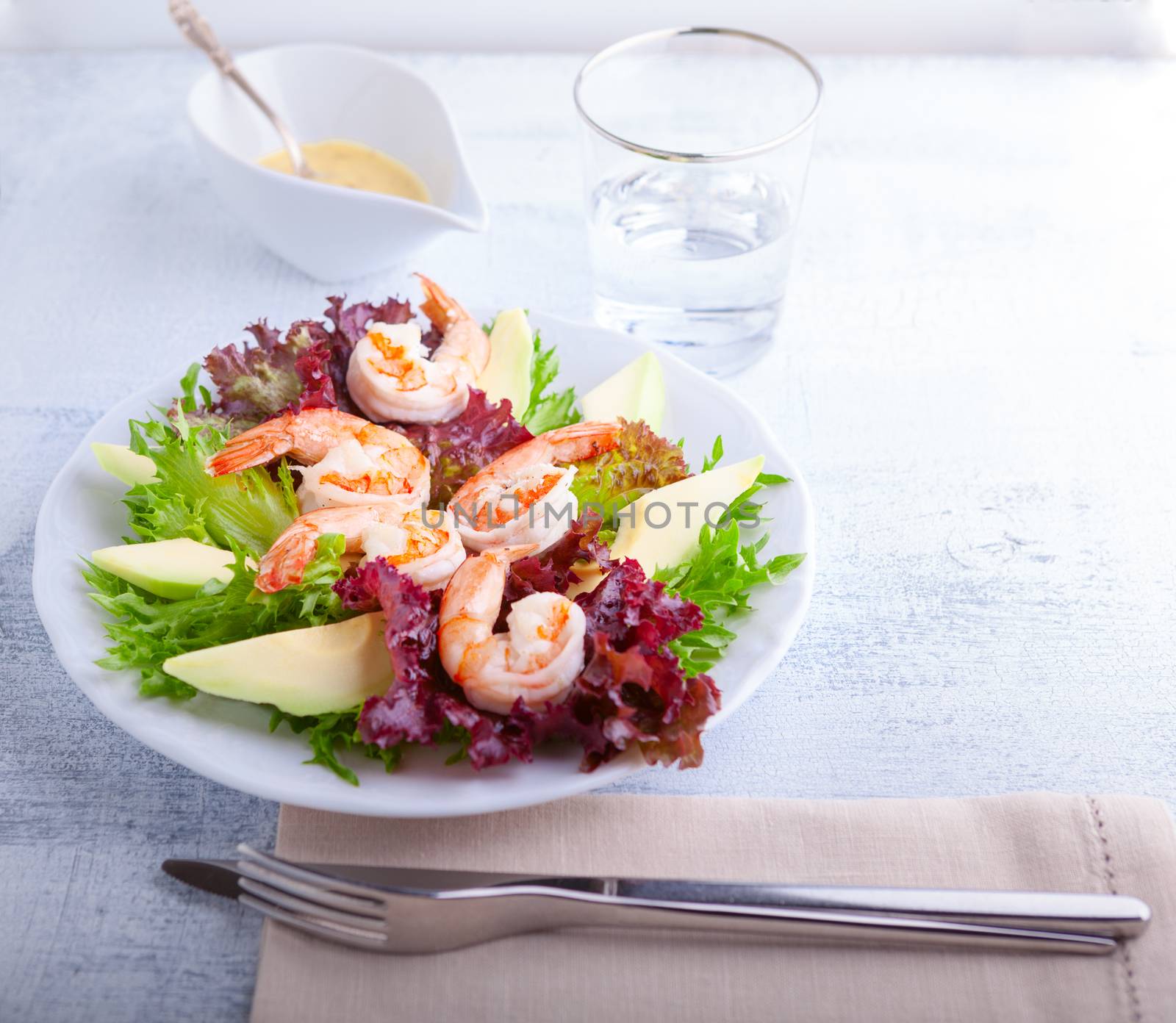 Avocado shrimp salad with mustard sauce on the table.