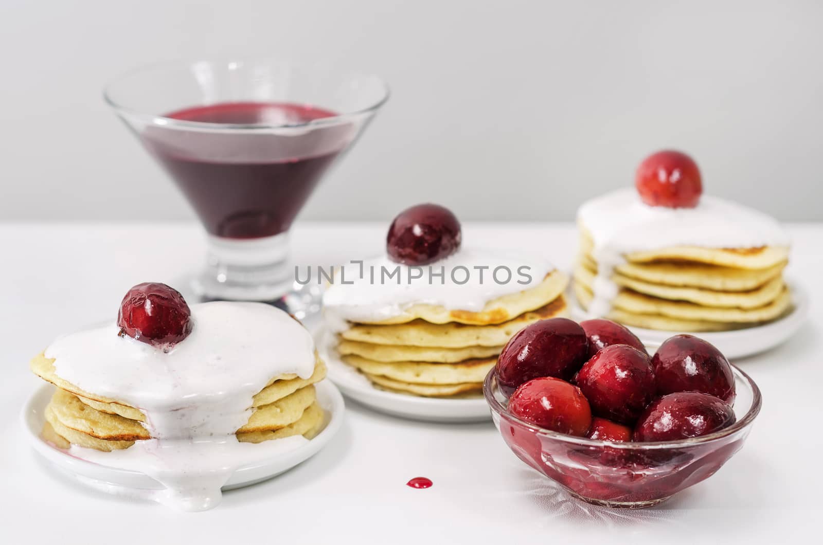 Pancakes with cream and jam. White surface  light grey background. Selective focus. by Gaina