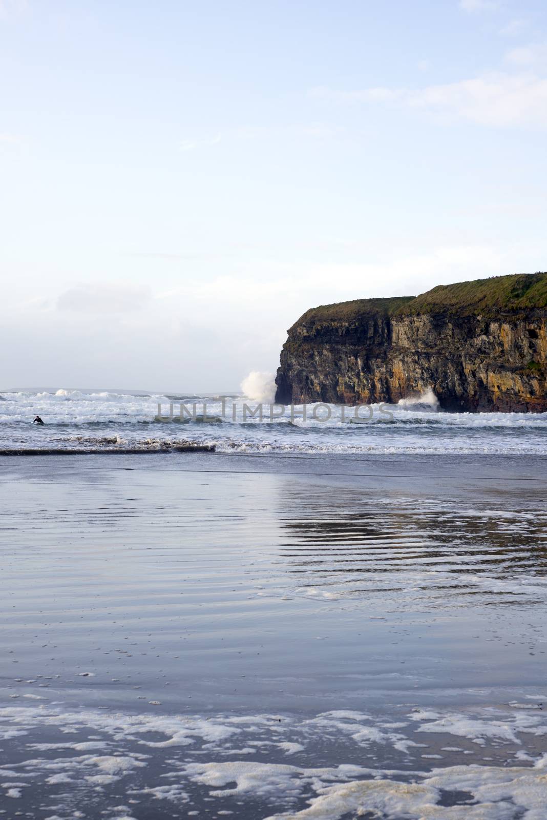 lone surfer surfing the winter waves by morrbyte