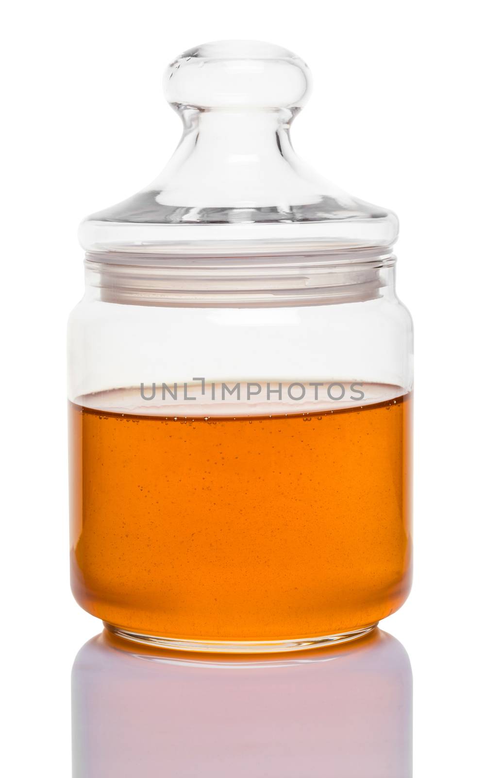 glass jar of honey on white background