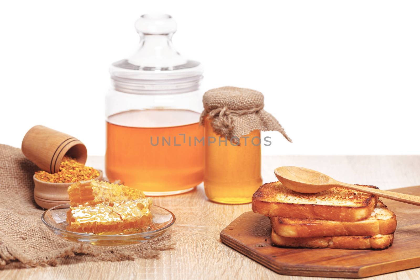 honeycomb, honey and toast on a white background