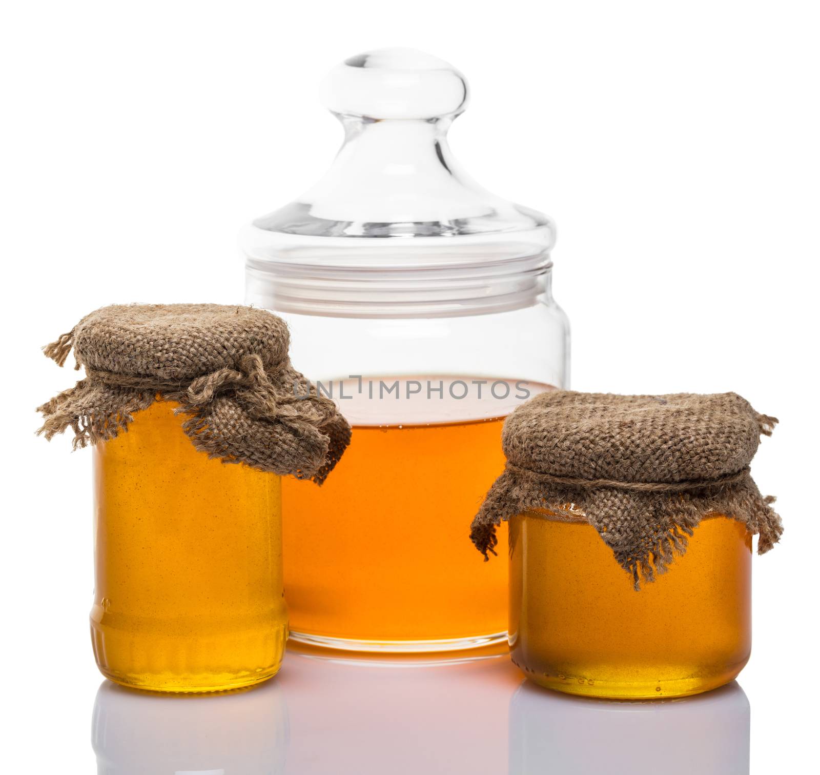 glass jars of honey on white background