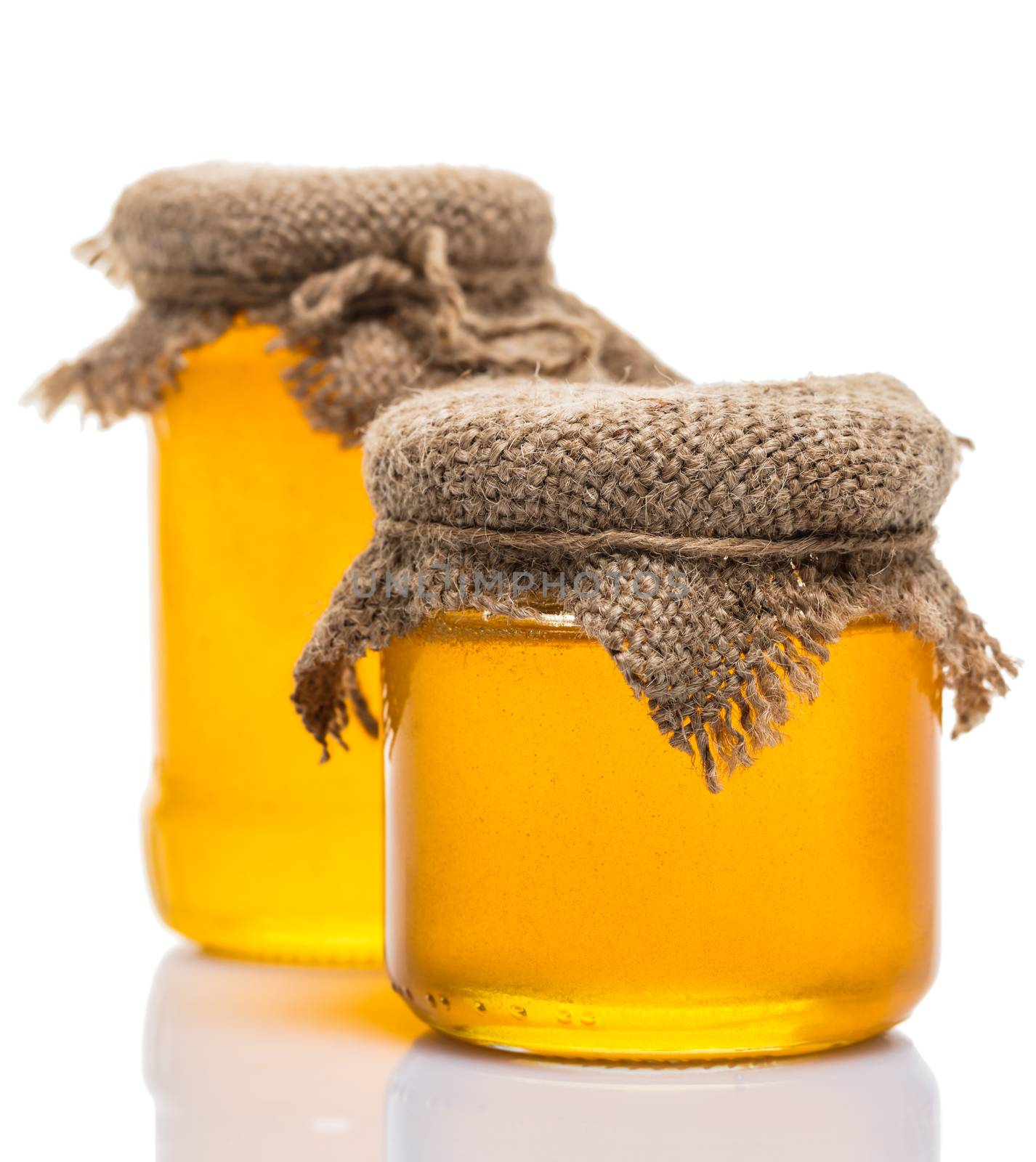 glass jars of honey on white background