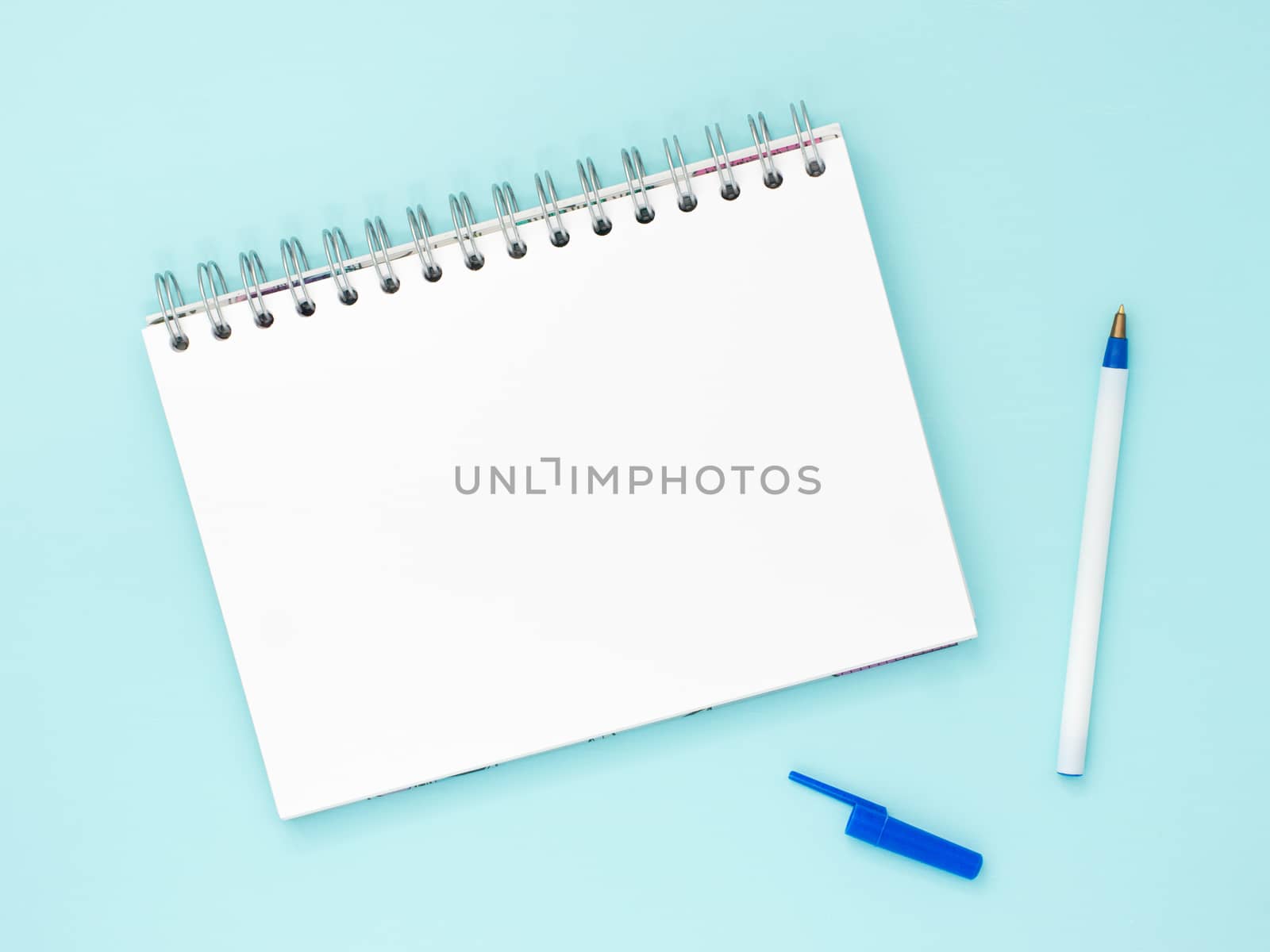 Top view of blank note paper with pen on blue wood table for background