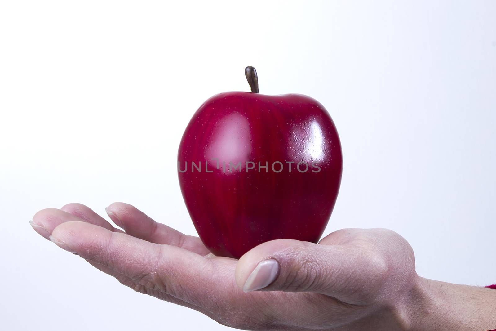 Arm and hand holing an apple isolated on white