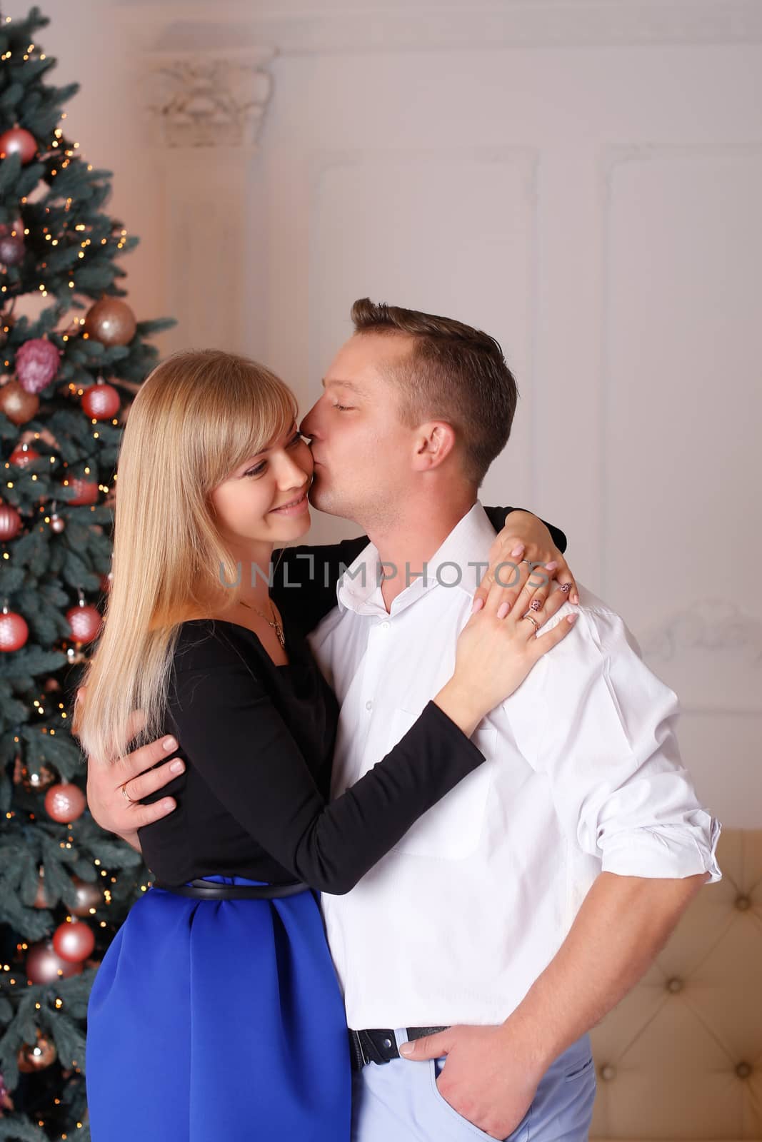 The man and the woman near the Christmas tree on Christmas Eve
