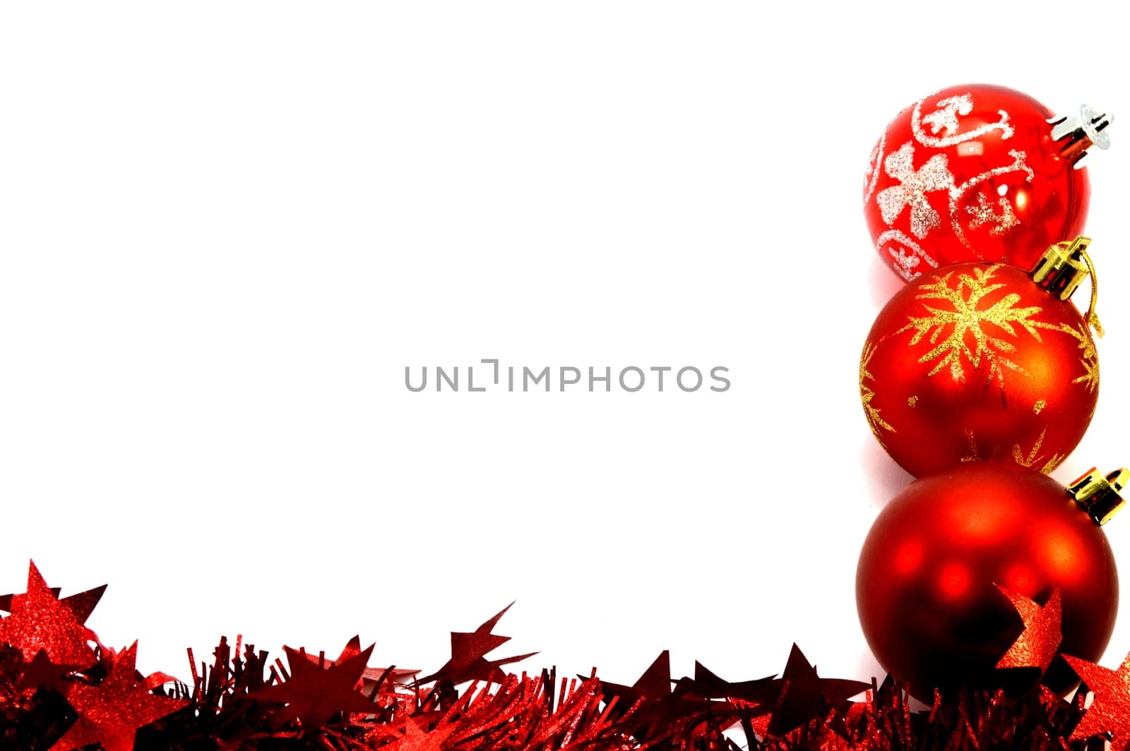 Three christmas balls and a red garland placing right vertically on a white background