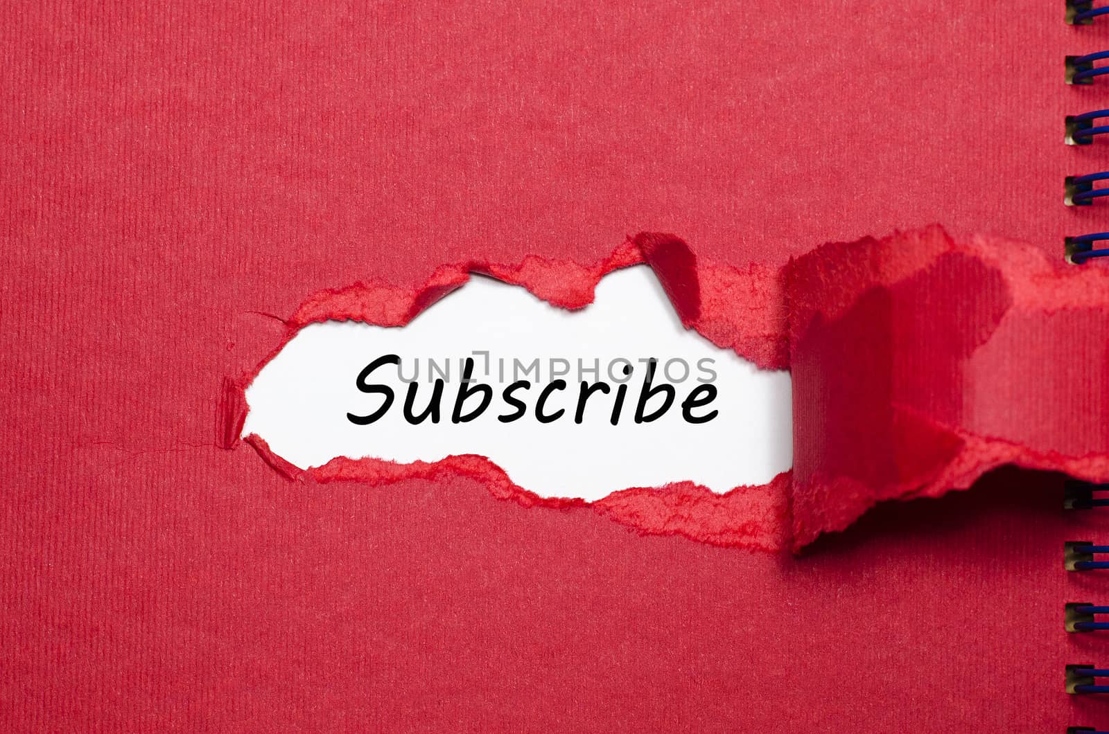 The word subscribe appearing behind torn paper