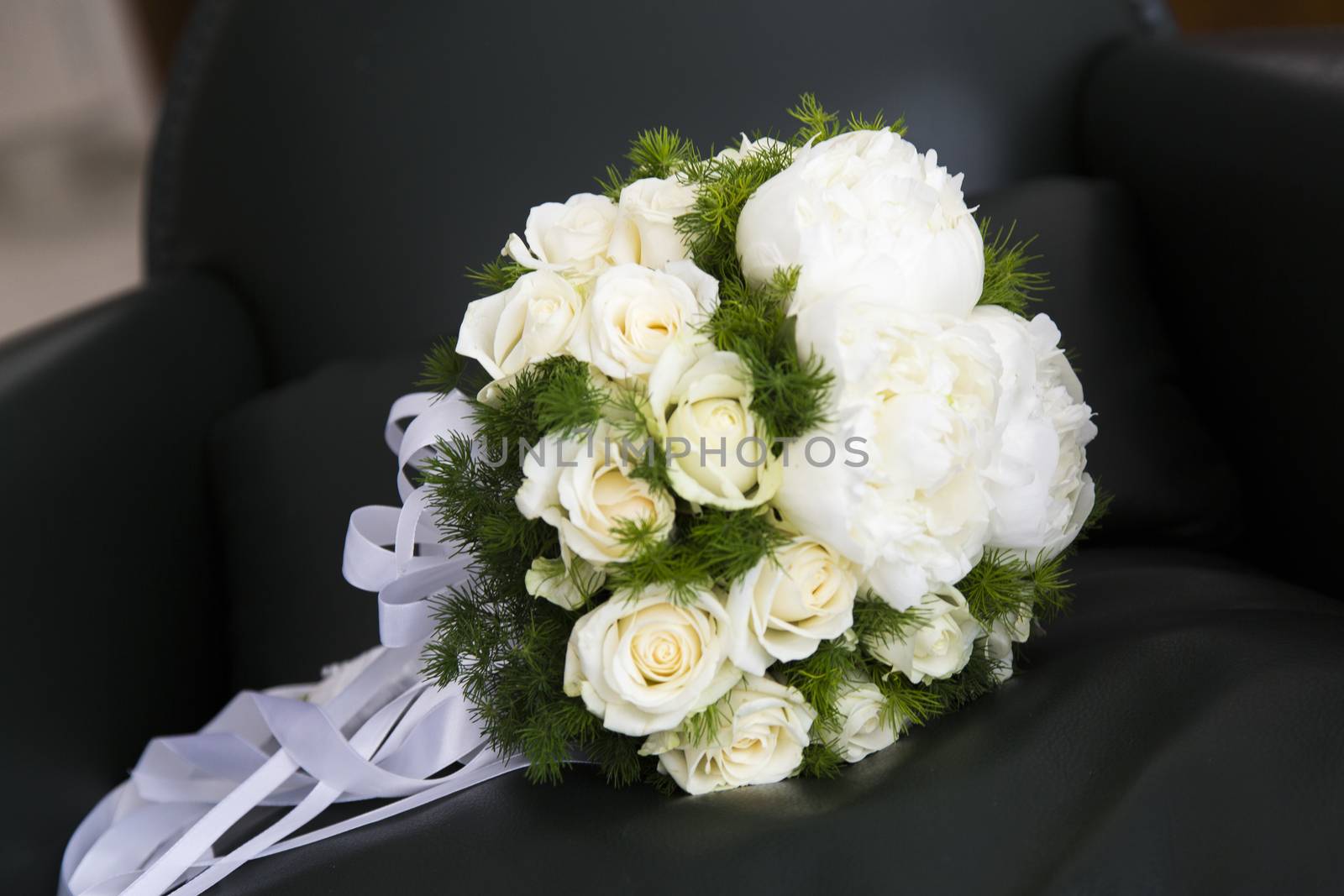 Close up view of a bridal bouquet put an armchair in a living room