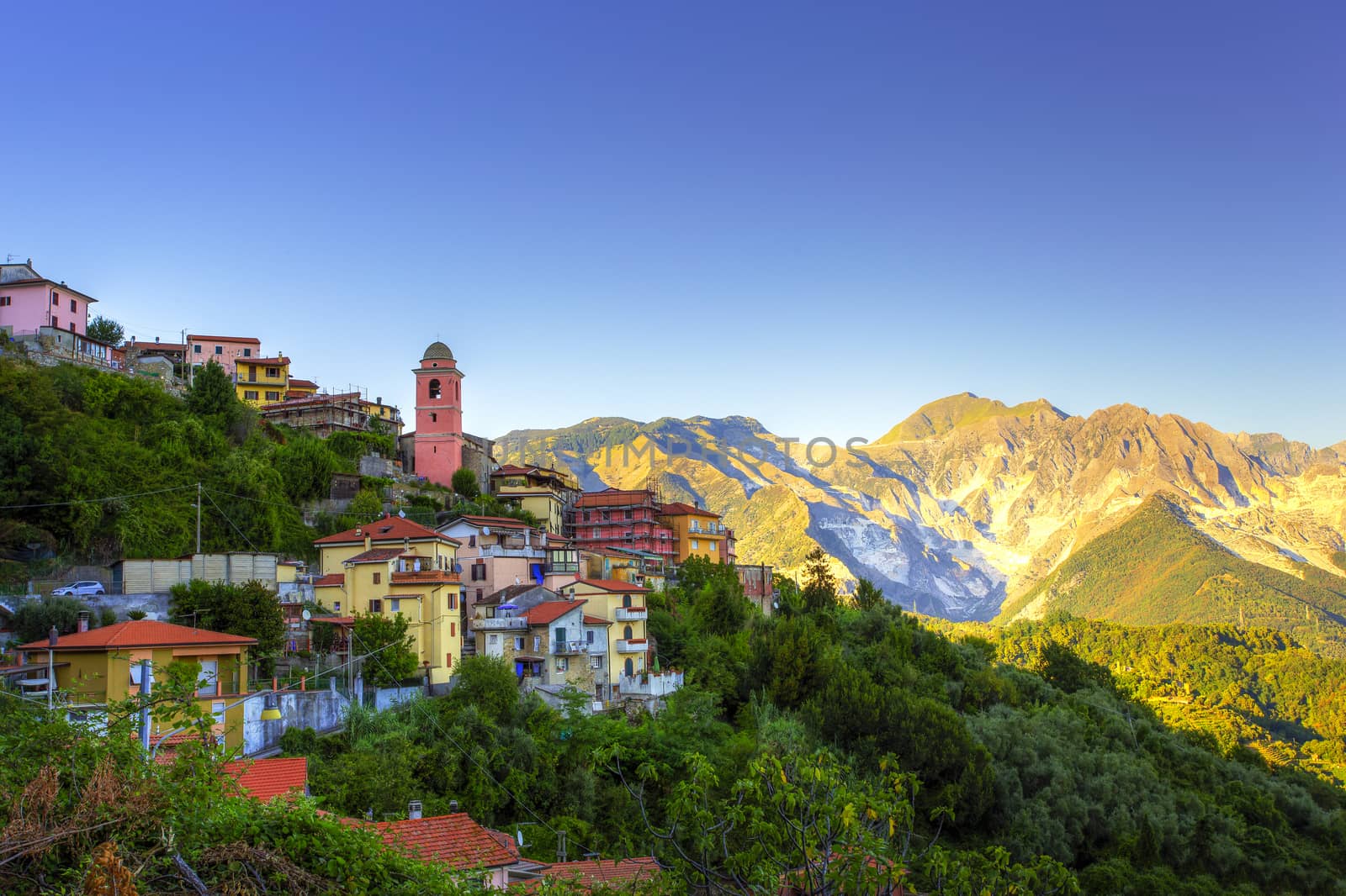 View of a mountain village at sunset with the quarries in the background